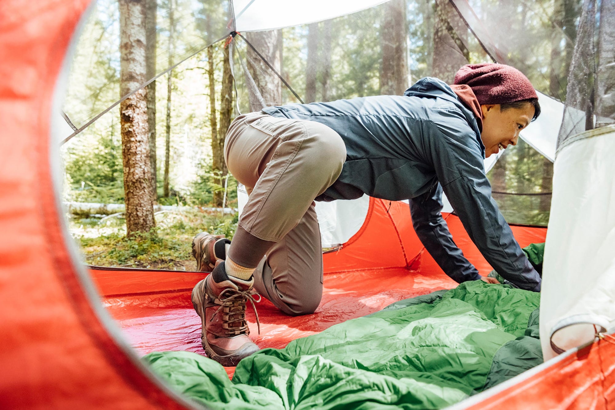 woman inside a tent setting up her sleeping bag