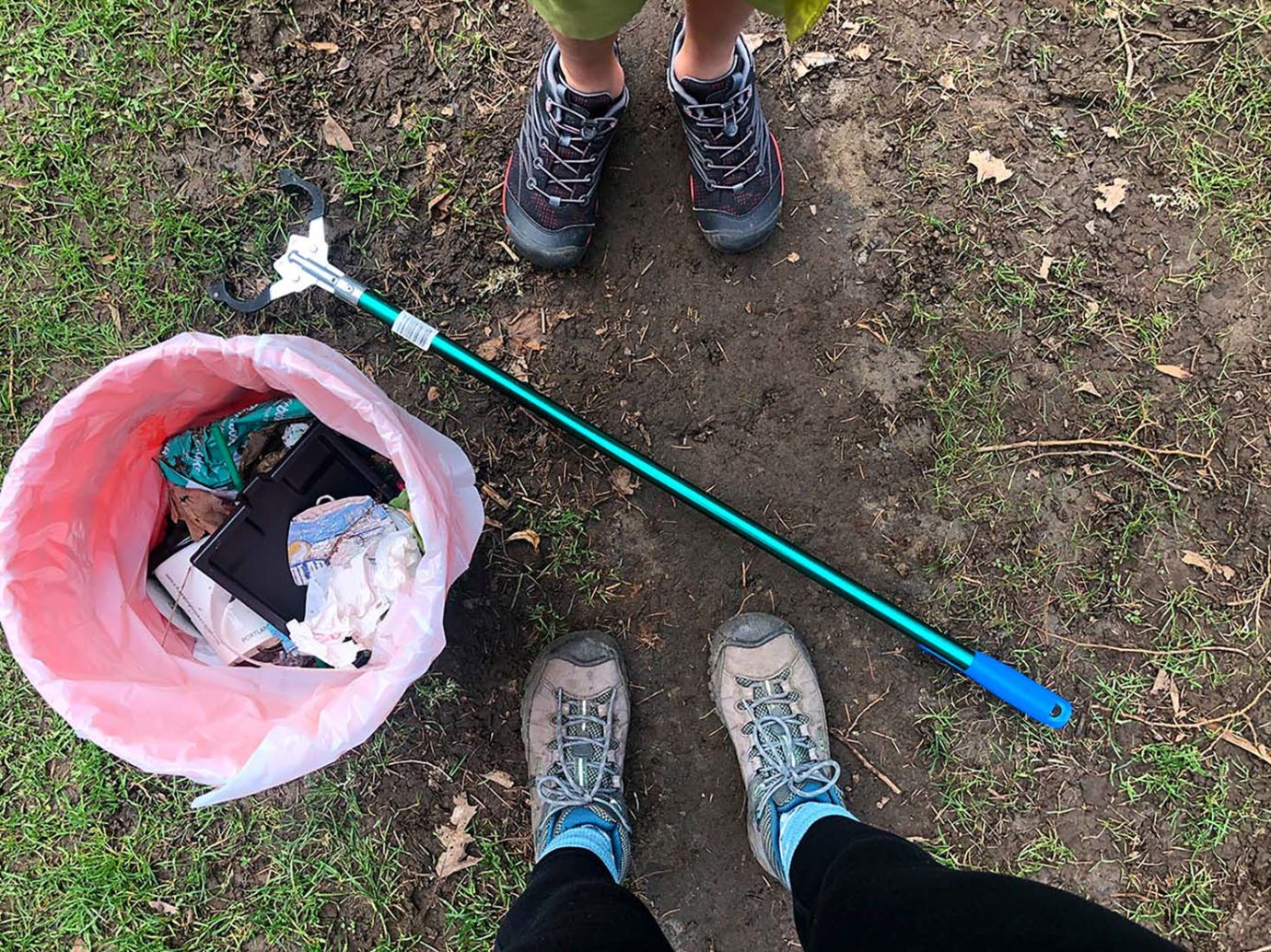 A parent and child picking up litter